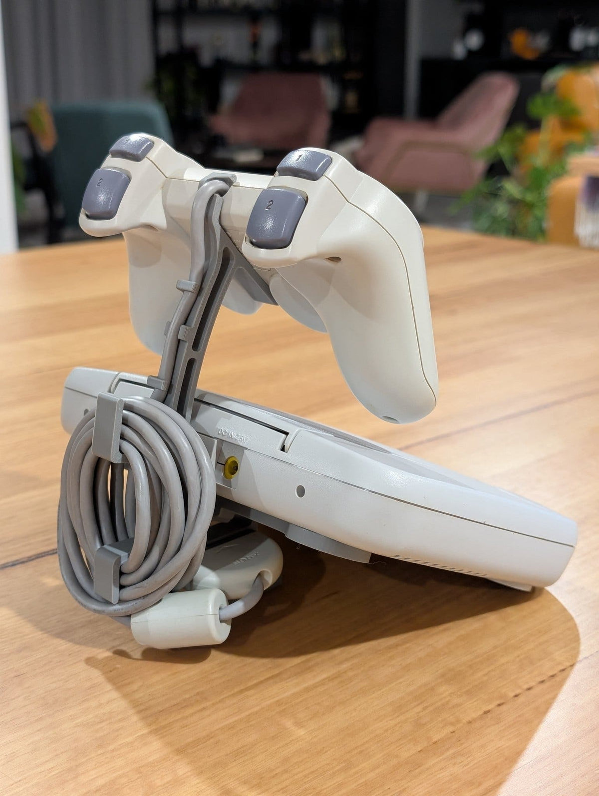 Konsolställ PSone med kontroll och kabel - sidovy